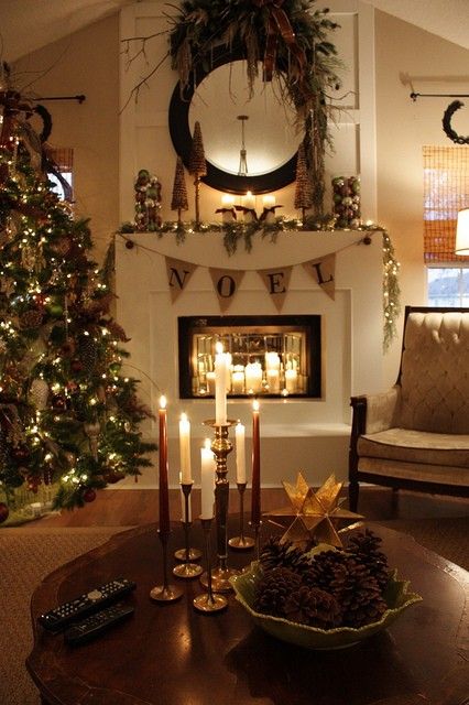 a rustic Christmas mantel with a burlap garland, Christmas ornaments, pinecones, greenery, a large bow and a bowl with pinecones on the table