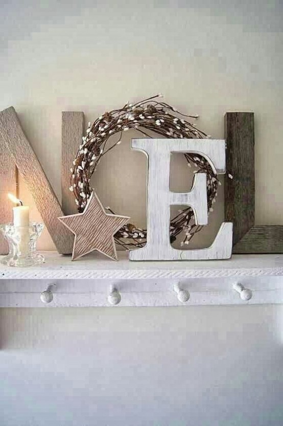 a Nordic rustic Christmas mantel done with wooden letters and a willow wreath as a letter plus a wooden star and a simple glass candleholder