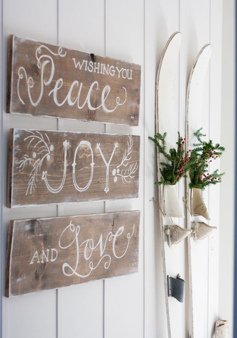 rustic Christmas decor with chalked signs, vintage white skis with evergreen and berry arrangements