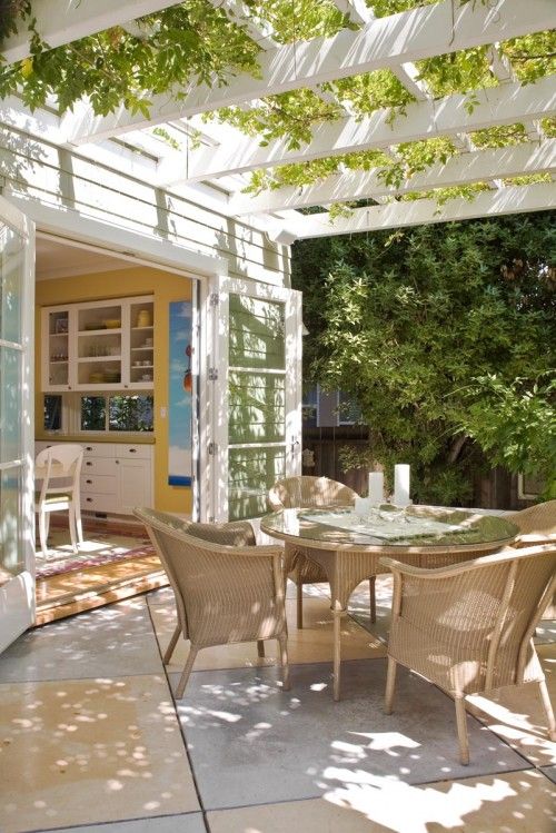 a neutral eat-in kitchen with doors to the garden that can be opened to eat outdoors, under a small roof with greenery