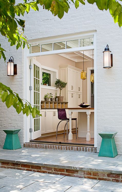 a white modern farmhouse kitchen with French doors that can be opened to connect the eating zone to outdoors and let some fresh air and light inside