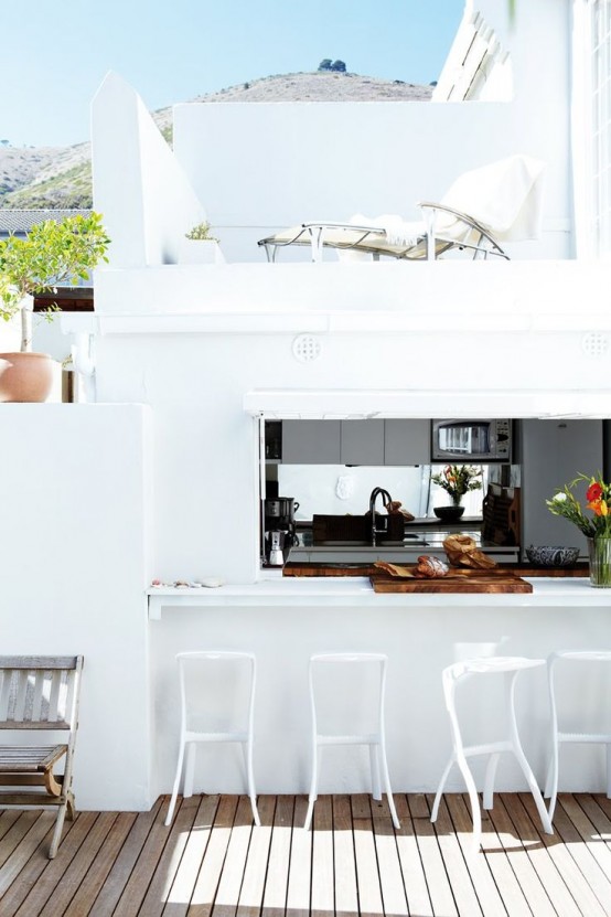 a white house with a pass through window and tall stools that is a great idea to serve some drinks and meals outdoors