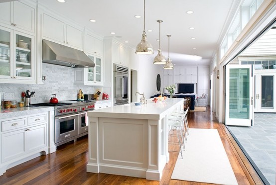 a traditional white kitchen with a folding glass wall that allows to open the kitchen ot the terrace and garden outside