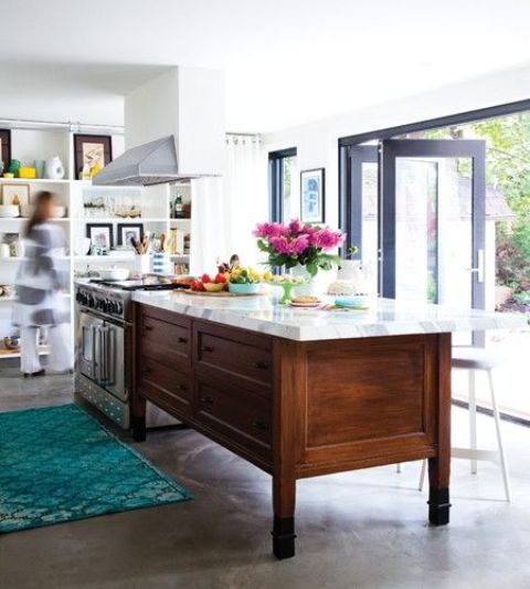 a modern eclectic kitchen with a folding wall that allows natural light and fresh air in and allows to comfortably connect indoors and outdoors
