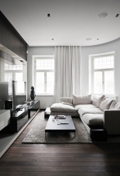 a monochromatic minimalist living room with dark stained furniture and a floor, white walls, curtains and a sofa