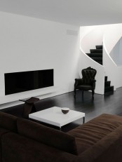 a minimalist black and white living room with elegant furniture and a dark brown sectional sofa
