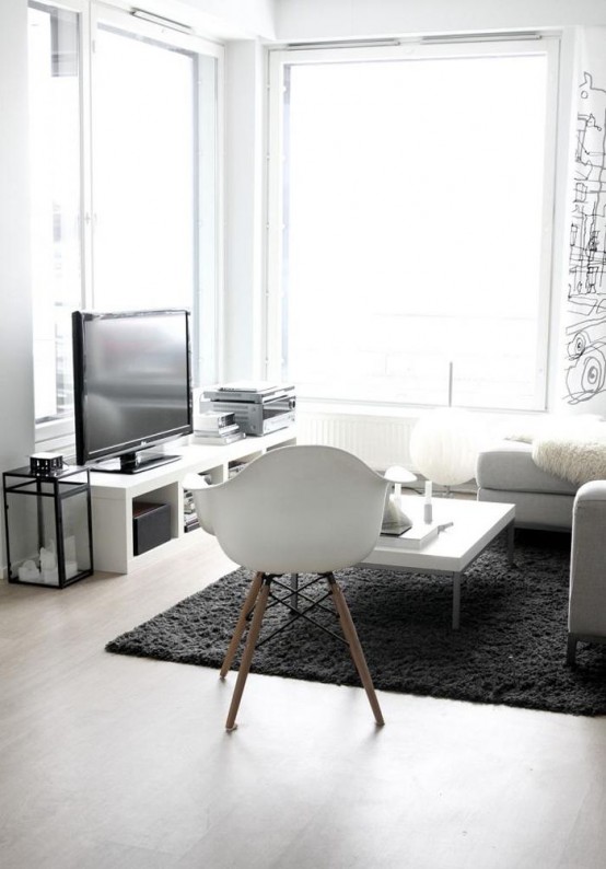 a minimalist monochromatic living room with laconic white furniture, panoramic windows, a fluffy rug and a printed statement wall