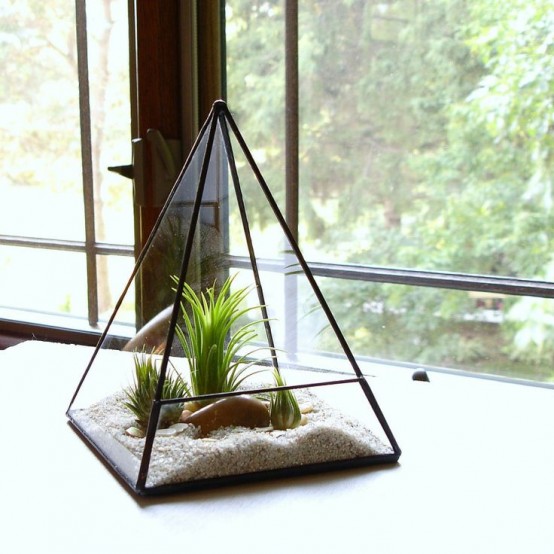 a triangle terrarium with sand, faux grass and pebbles is an elegant decoration that doesn't require any care