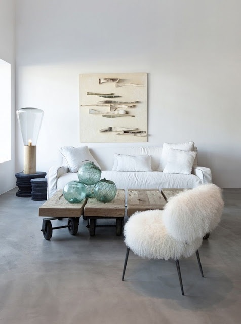 a white faux fur chair softens the modern industrial space in neutral tones and makes it welcoming