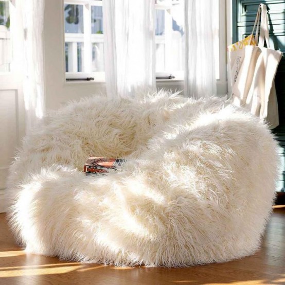a large white faux fur chair to dip inside it is a gorgeous and super cozy piece for a reading nook