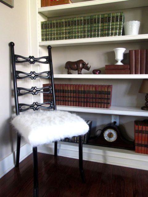 a vintage black chair with a white faux fur seat is a cozy and welcoming piece for a reading nook