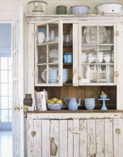 a whitewashed buffet with a planked and a glass part is a chic solution for a vintage or shabby chic space