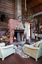 an eclectic living room with cabin touches – much wood, a large fireplace and a firewood storage