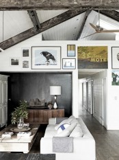shiplap and reclaimed wooden beams add a cozy rustic feel to the living room