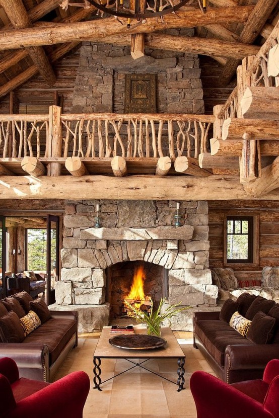 a cabin living room with a stone fireplace, a wooden staircase with beams, elegant furniture