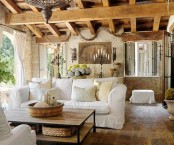 a Provence living room with a wooden beam ceiling, stone walls and chic furniture