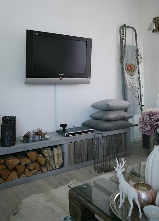 a modern rustic living room with reclaimed wood, firewood storage and a ladder by the wall