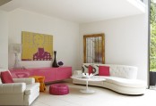 an elegant feminine living room in white and pink, with a curved sofa, a pink floating credenza, a white chair and some pink pillows and a pouf