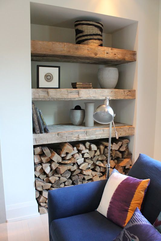 a niche styled with wooden shelves, for storing firewood, photos, baskets and planters