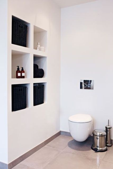 a minimalist bathroom with a series of niche shelves for storing all kinds of bathroom stuff, which is a very practical idea