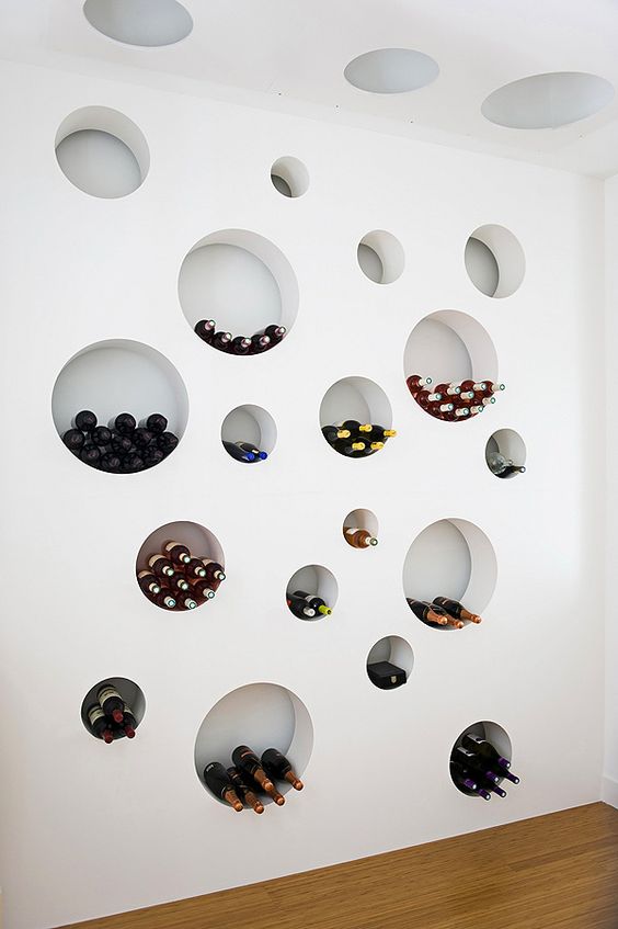 an arrangement of round niche shelves is great for a dining space, here it's used for storing wine bottles