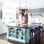 a catchy ocean-inspired kitchen with white and grey shaker cabinets, ocean blue tiles over the cooker, a metal hood, a turquoise kitchen island and dark stained stools