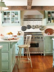 an aqua-colored kitchen with shaker style cabinets, white stone countertops, stainless steel appliances and a white tile backsplash