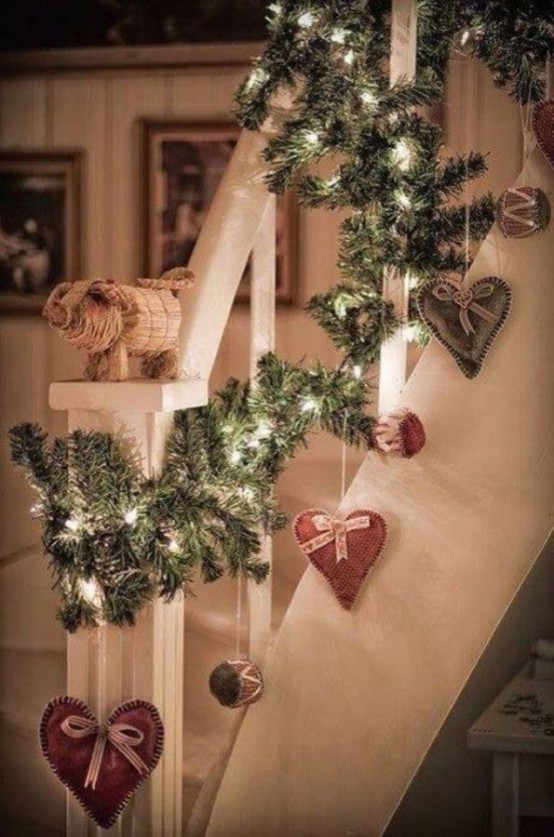 an evergreen garland with lights and fabric hearts is a cool decor idea for a rustic or Scandinavian space