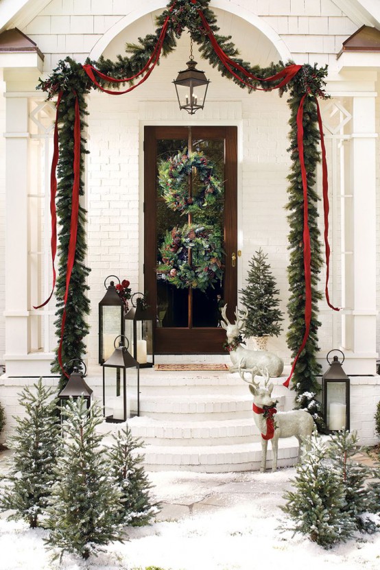 an evergreen garland with red ribbon is a bold decoration for outdoors or for the entryway, it looks chic and elegant