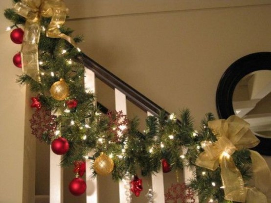 a lush Christmas garland of evergreens, red and gold ornaments and snowflakes plus gold ribbon and lights is a chic and cool idea