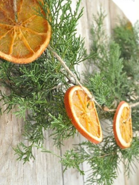 a natural Christmas garland of orange slices and evergreens is a cool decor idea to add a rustic or natural space