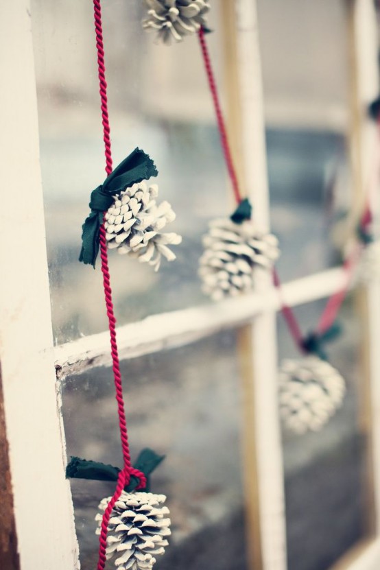 a snowy pinecone garland with black bows is a cool decor idea for any Christmas space, for a rustic or woodland one especially