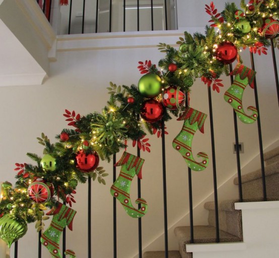 a colorful evergreen garland with red and green ornaments, matching stockings and lights is a very catchy and cool idea