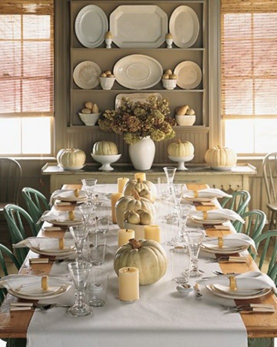 neutral pumpkins paired with pillar candles form a lovely rustic fall centerpiece for a vintage-inspired table setting