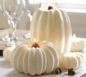 a white pumpkin centerpiece of faux pumpkin candles is a cool and cozy idea for the fall