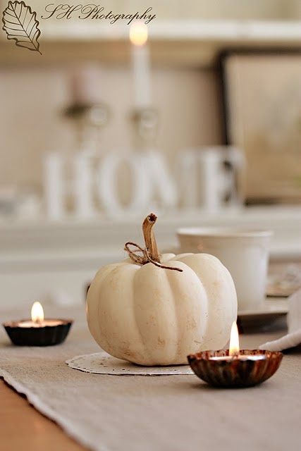 a white pumpkin with candles is a simple and chic rustic fall centerpiece to match your tablescape
