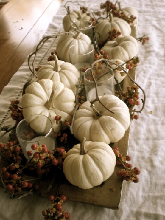 a tray with white pumpkins, berries and pillar candles in glasses is a neutral and peaceful fall centerpiece