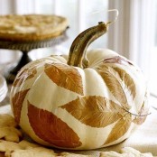 a white pumpkin with decoupaged fall leaves for a cozy fall centerpiece or just decor