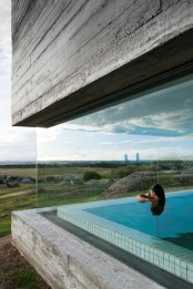 a large indoor pool with an infinity edge and glazed walls that allow to enjoy the landscapes around is a super contemporary and bold idea
