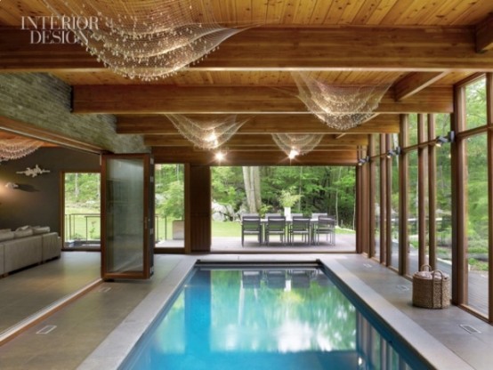 an indoor-outdoor pool located in a pavilion that can be opened to outdoors if the weather is fine, with amazing views of the forest around