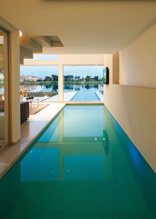 a minimalist chill out zone with a sitting zone, an indoor pool that comes outside into an outdoor pool and a glazed wall to enjoy the views that can be moved to feel outside