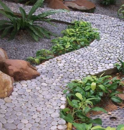 a polished pebble path in grey is a chic idea that will match most of garden styles and decor