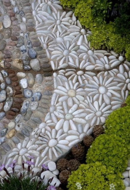 a catchy pebble path in several colors and with daisies made of pebbles looks super cute and rustic