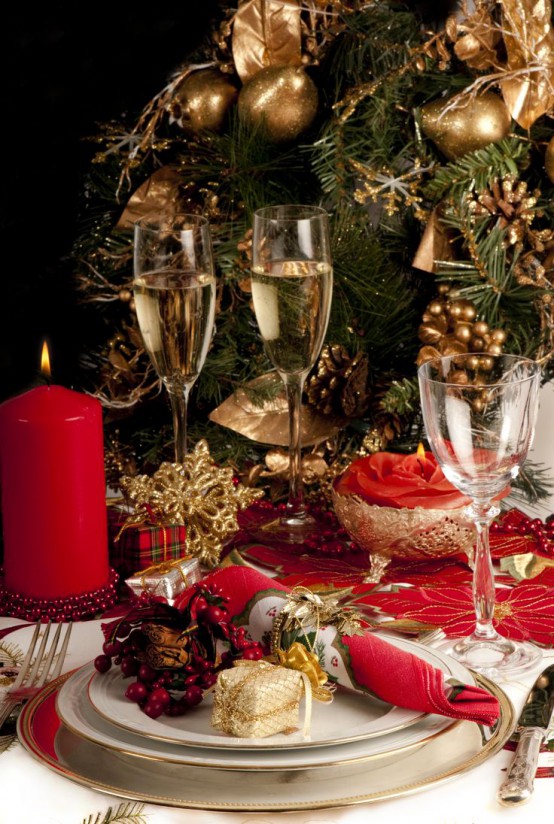 gold and red Christmas styling with candles, gilded chargers and cutlery, placemats and a tree decorated with gold ornaments