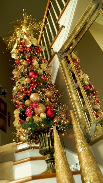 a red and gold Christmas mini tree composed of ornaments and bows is a shiny festive decoration