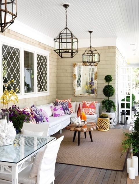 a bright spring porch with lots of greenery, bright throws and blooms feels like the season