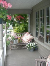pink and white blooms in pots and crates and matching bright pillows for a bold spring porch