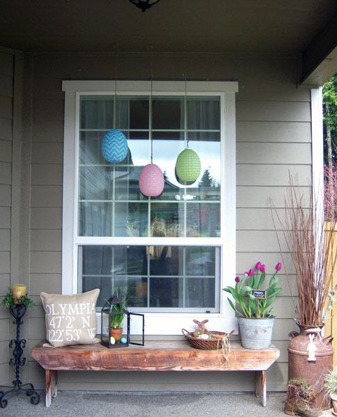 pink potted tulips, large fake eggs, potted greenery and pastel eggs plus a plush bunny for a spring or Easter porch