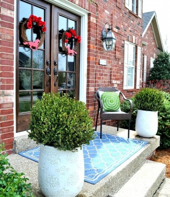 lush greenery in large pots and colorful wreaths on the doors will spruce up your porch for spring
