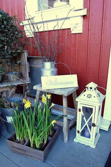 branches in a churn, candle lanterns, potted yellow daffodils for a bright and cozy spring look